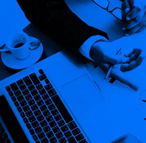 Photograph of a laptop and a cup of coffee in a duotone style